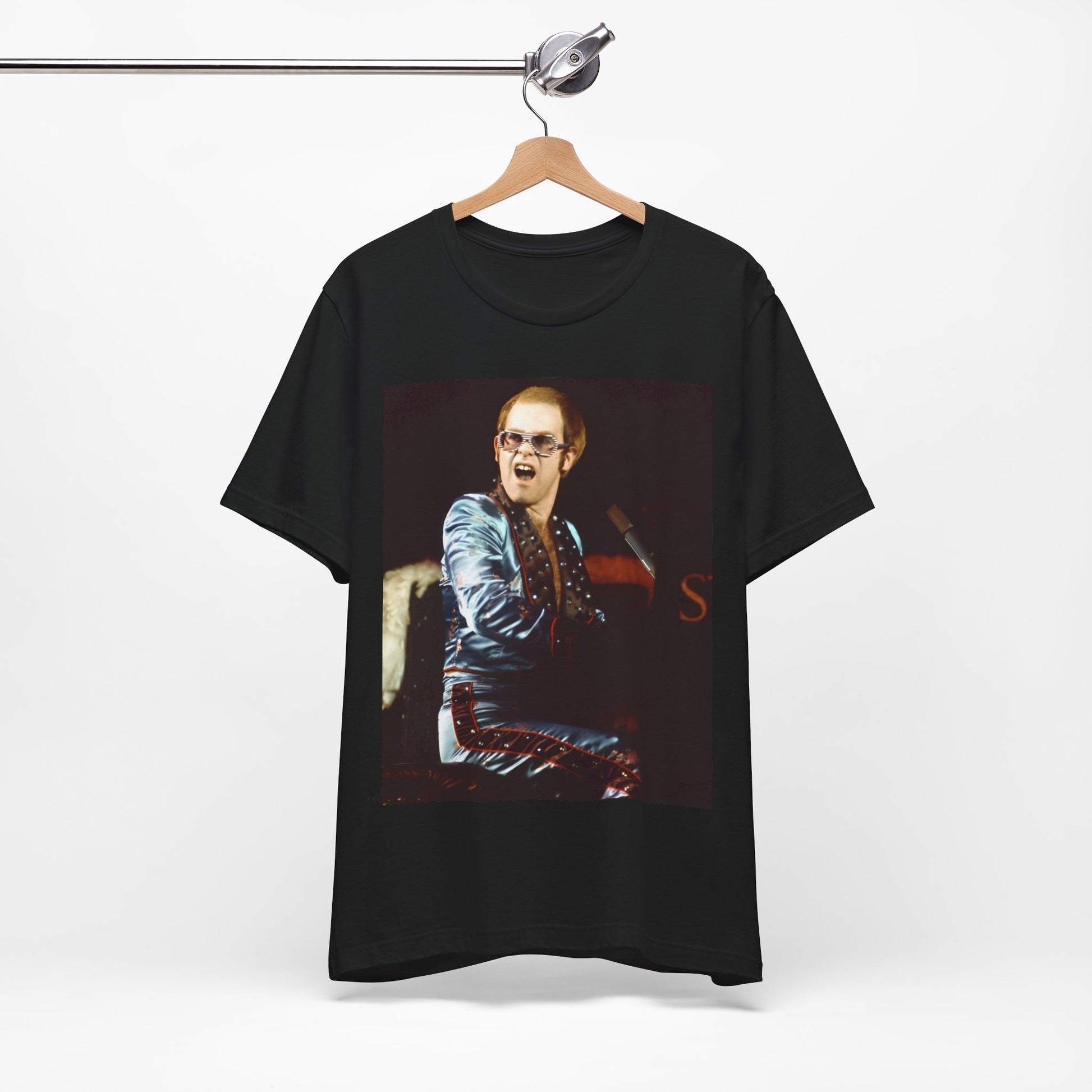 A black graphic t-shirt featuring a retro graphic related to Elton John's 'Rocket Man' song or era.