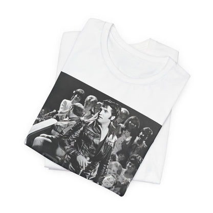 A black graphic t-shirt featuring a vintage black and white photo or graphic of Elvis Presley performing live on stage.