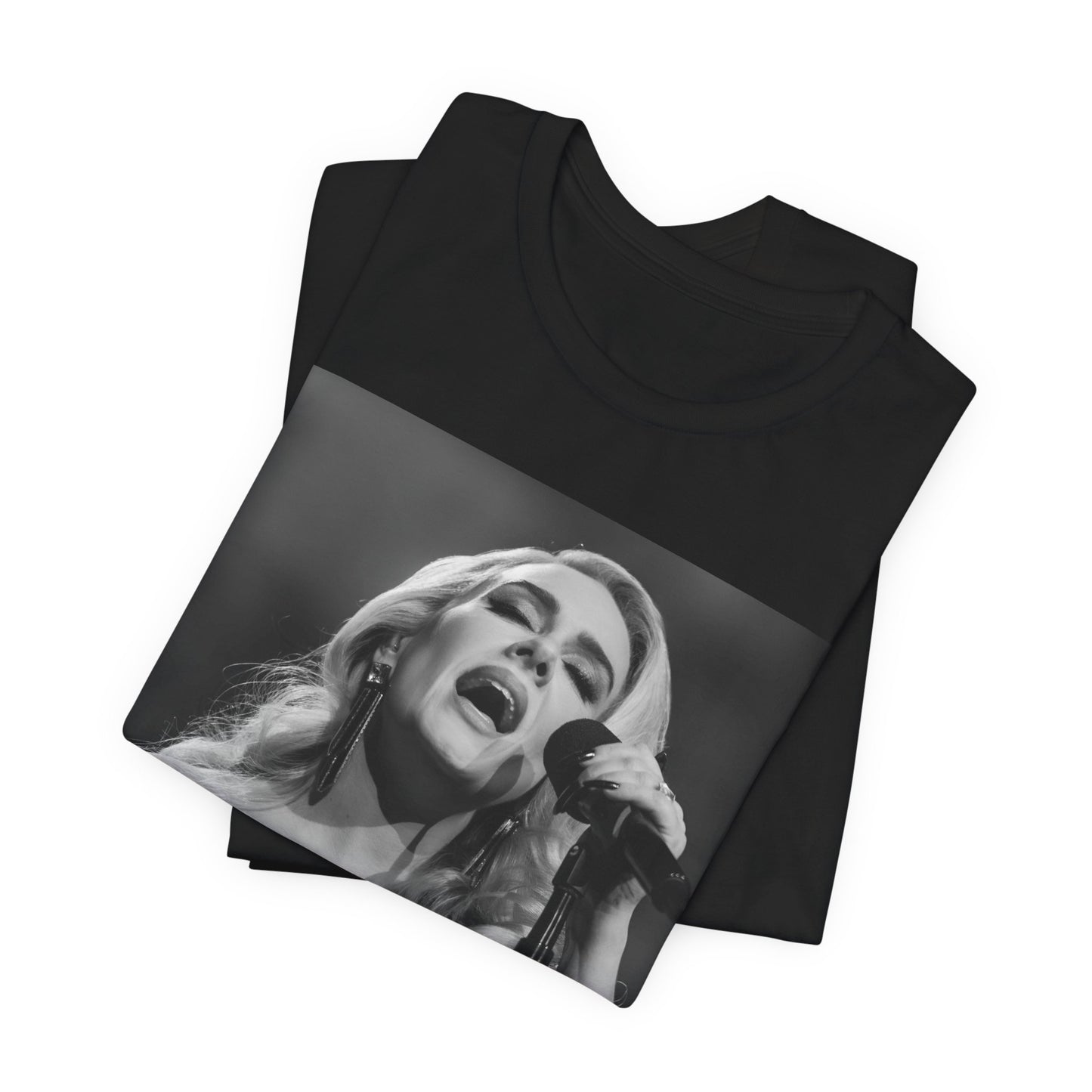 A black graphic t-shirt featuring a dynamic image of Adele performing on stage, with lighting effects, likely from her 'One Night Only' concert special.