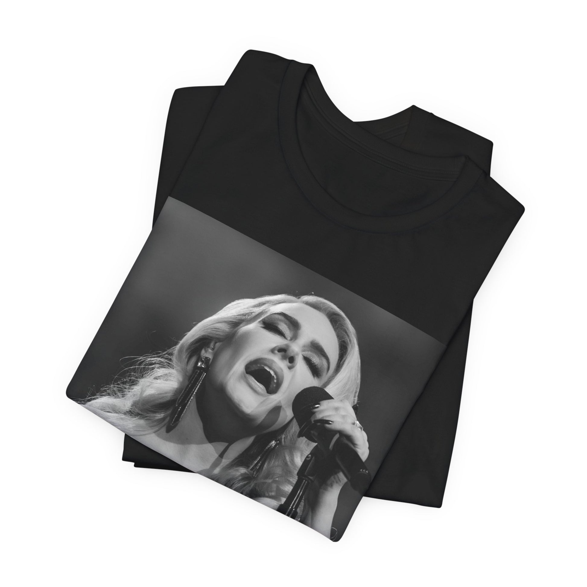 A black graphic t-shirt featuring a dynamic image of Adele performing on stage, with lighting effects, likely from her 'One Night Only' concert special.