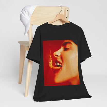 A close-up, red-toned photo of a face in profile with its mouth open and a live flame on the tongue, printed on a graphic t-shirt.