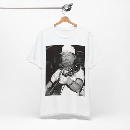 A black graphic t-shirt featuring a 70s cool free spirit graphic of Willie Nelson.