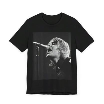 A black graphic t-shirt featuring a black and white graphic or photo of Liam Gallagher from Oasis performing live on stage.