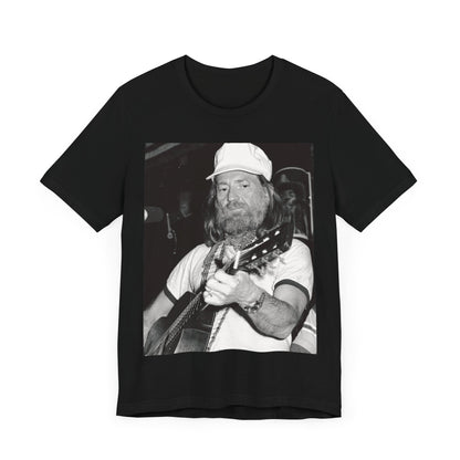 A black graphic t-shirt featuring a 70s cool free spirit graphic of Willie Nelson.