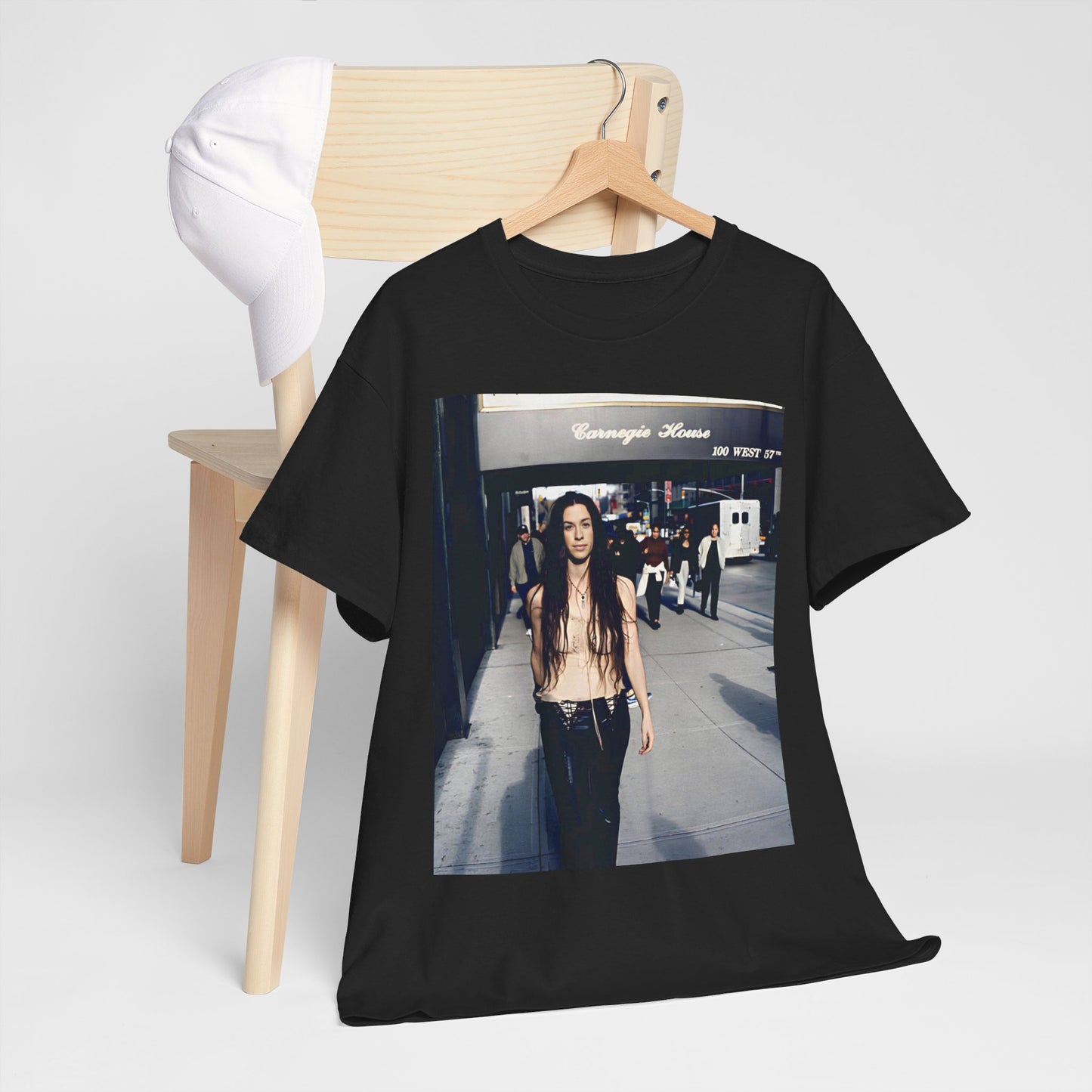 A black graphic t-shirt featuring a 90s-style graphic of Alanis Morissette with New York City elements or skyline in the background.