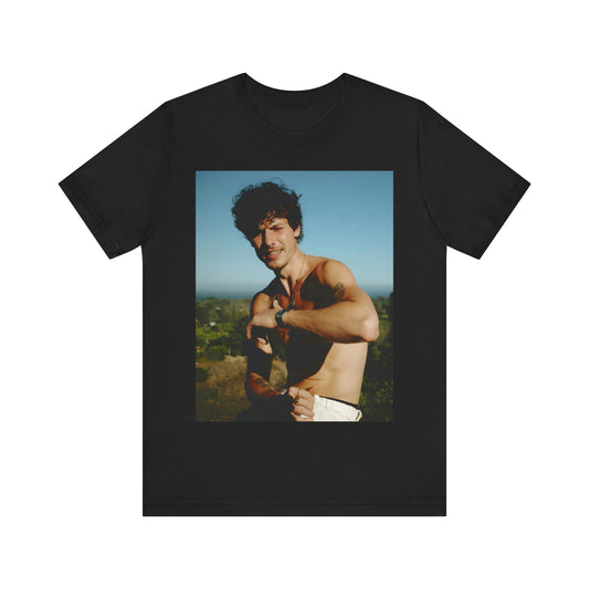 A black graphic t-shirt featuring a graphic of Shawn Mendes with a chill pop star look.