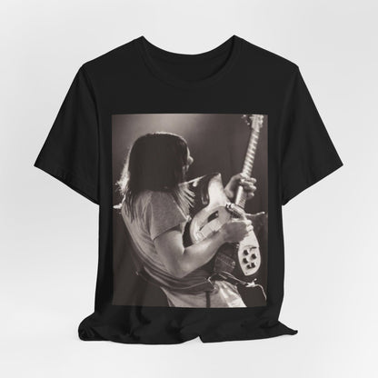 A black graphic t-shirt featuring a black and white graphic or photo of Tame Impala performing live on stage.