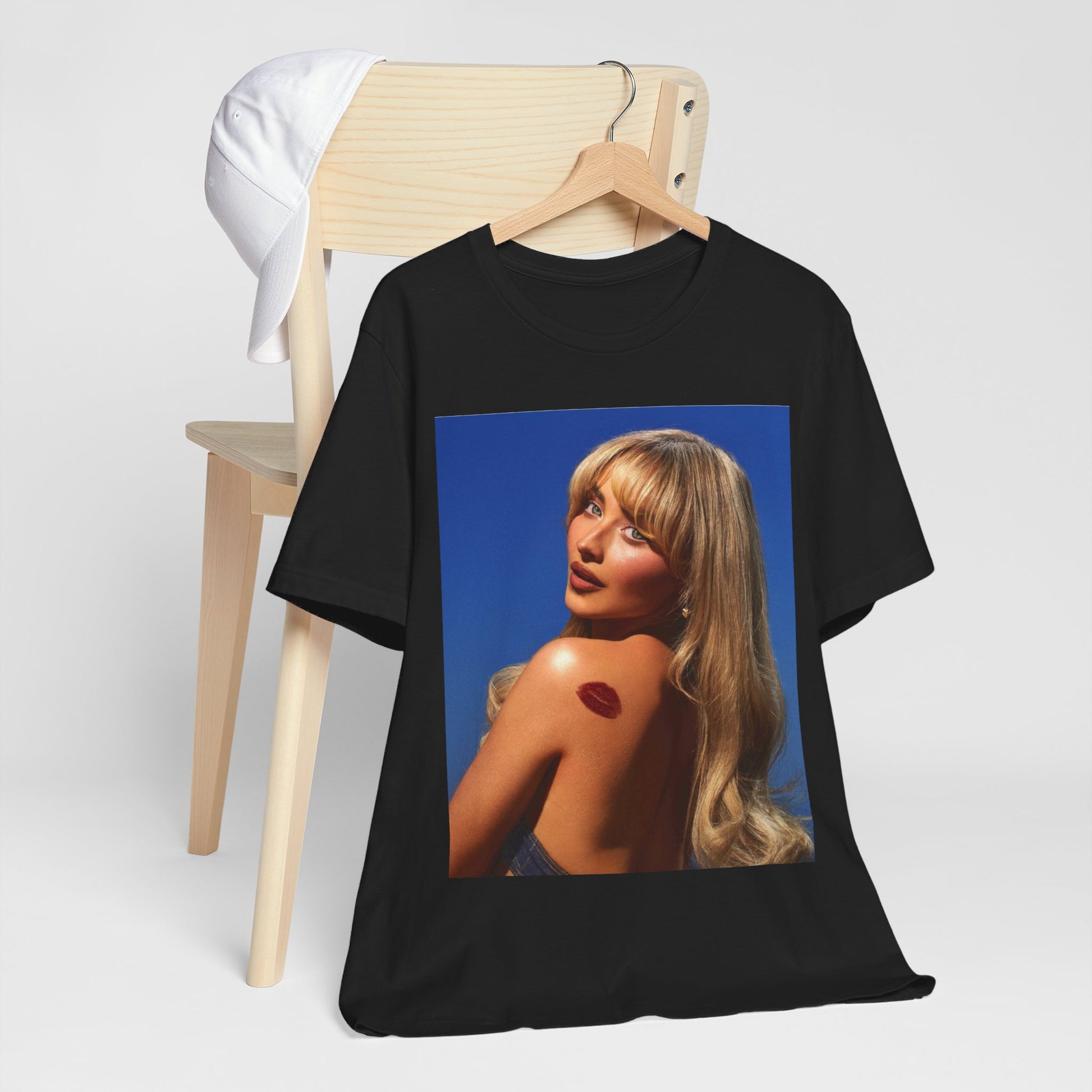 A black graphic t-shirt featuring a stylized graphic of Sabrina Carpenter, designed with a modern pop aesthetic.
