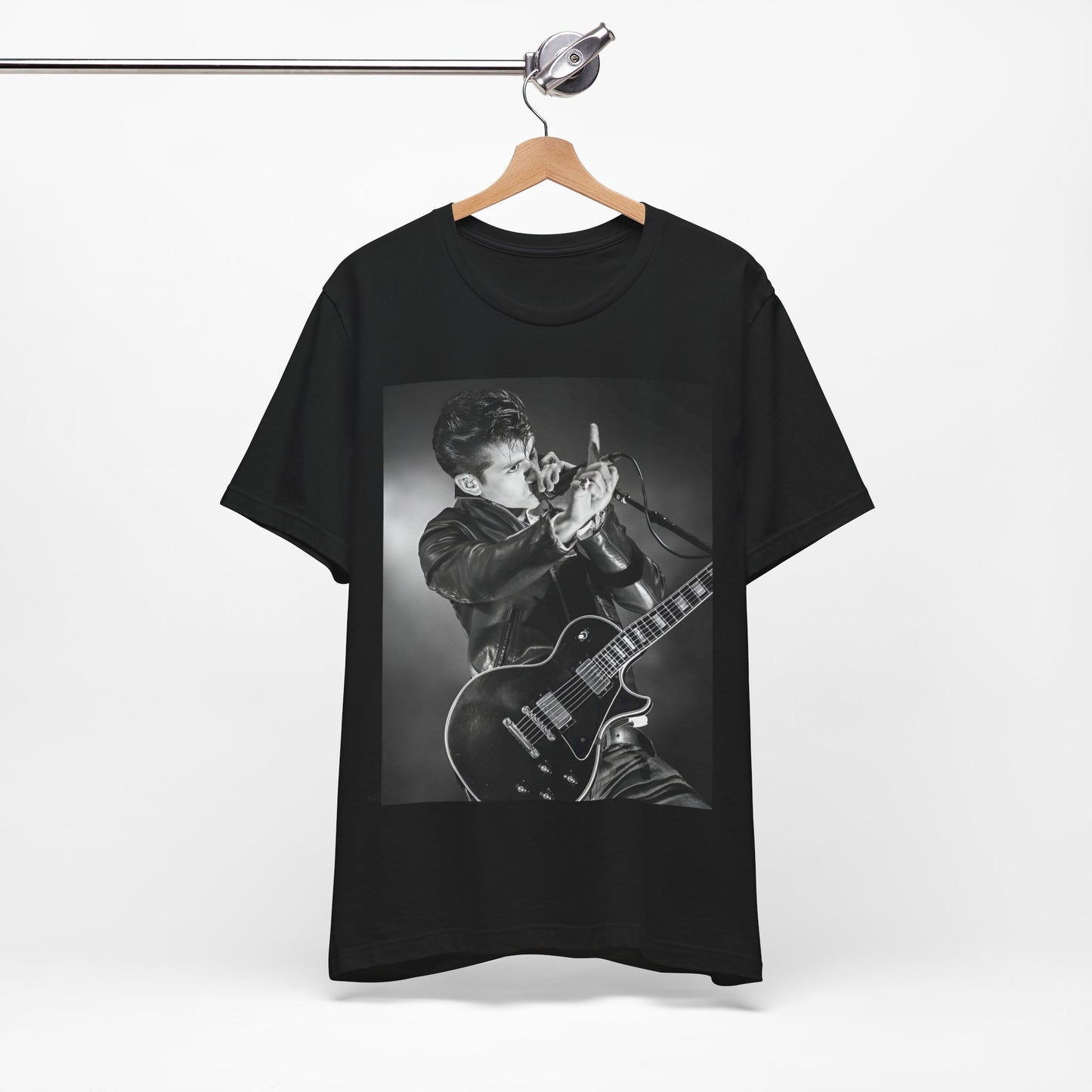 A black graphic t-shirt featuring a dynamic black and white graphic or photo of Arctic Monkeys performing live, emphasizing energy.