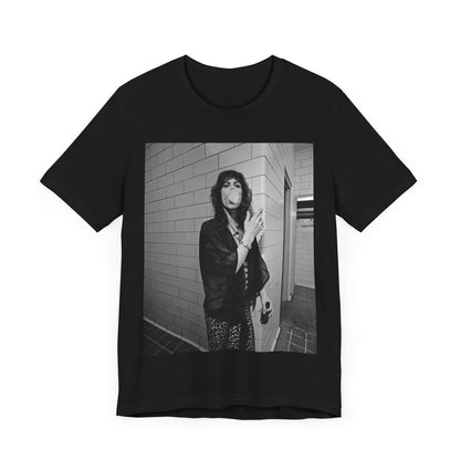 A black graphic t-shirt featuring a retro 70s photo of Aerosmith band members in a backstage setting, showing a candid moment.