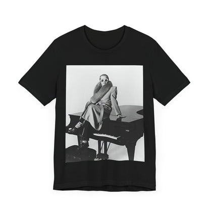 A black graphic t-shirt featuring a black and white photo of Elton John playing the piano.