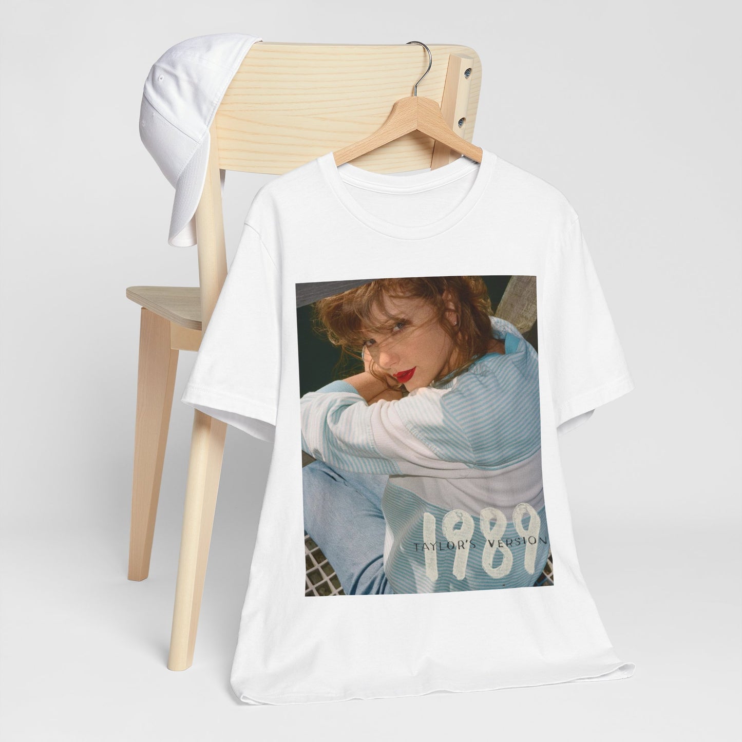 A black graphic t-shirt featuring a 1989 aesthetic graphic of Taylor Swift.