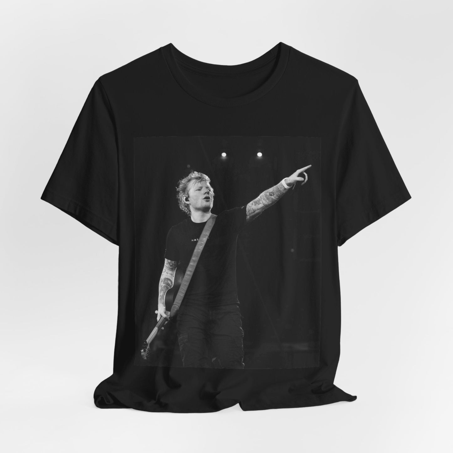 A black graphic t-shirt featuring a black and white graphic or photo of Ed Sheeran performing live on stage.
