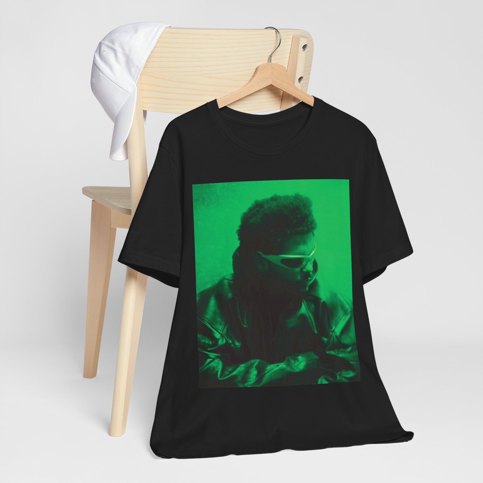 A black graphic t-shirt featuring a vintage graphic related to The Weeknd's 'Kiss Land' era.