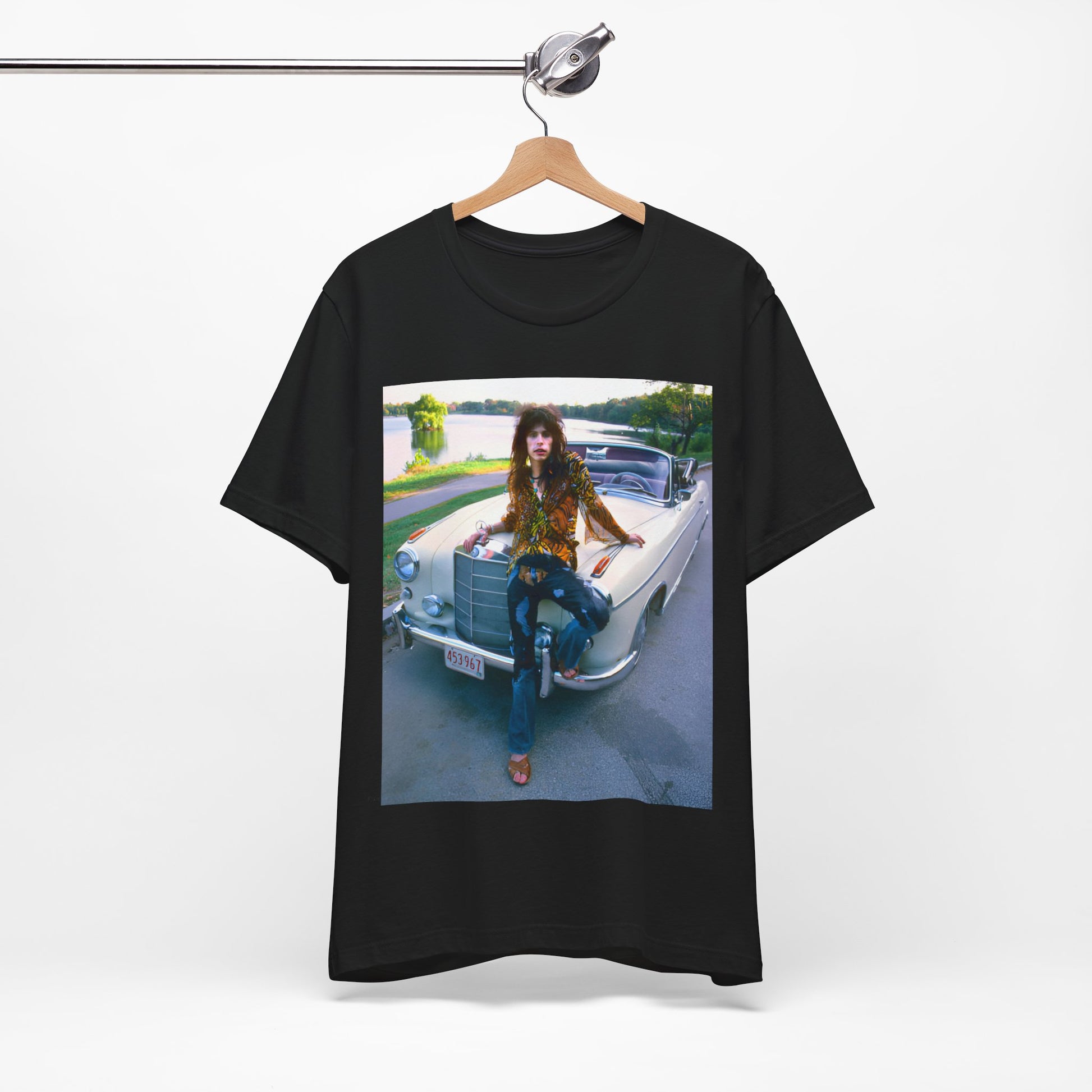 A black graphic t-shirt featuring a retro 70s photo of Aerosmith band members in a bohemian style, posing with a classic Mercedes car.