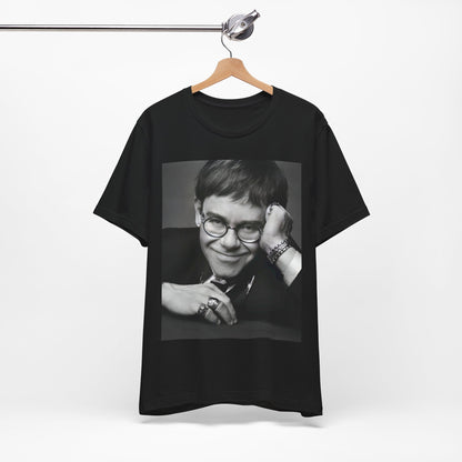 A black graphic t-shirt featuring a retro black and white photo portrait of Elton John.