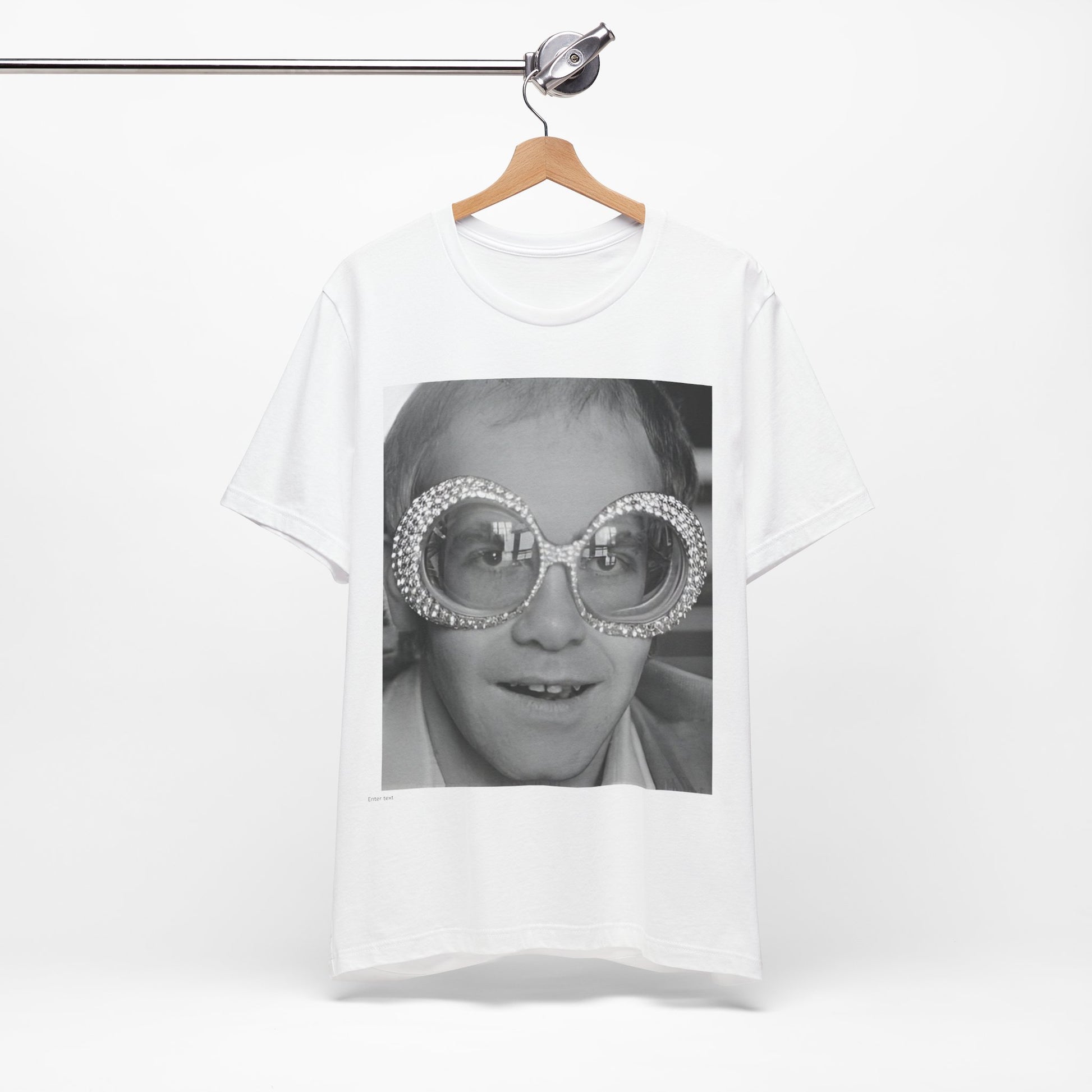 A black graphic t-shirt featuring a graphic of Elton John emphasizing his iconic glasses and fashion.