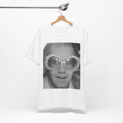 A black graphic t-shirt featuring a graphic of Elton John emphasizing his iconic glasses and fashion.