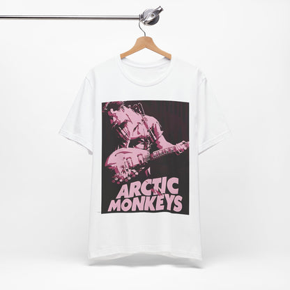 A black graphic t-shirt featuring the Arctic Monkeys logo in a prominent pink color, creating an aesthetic look.