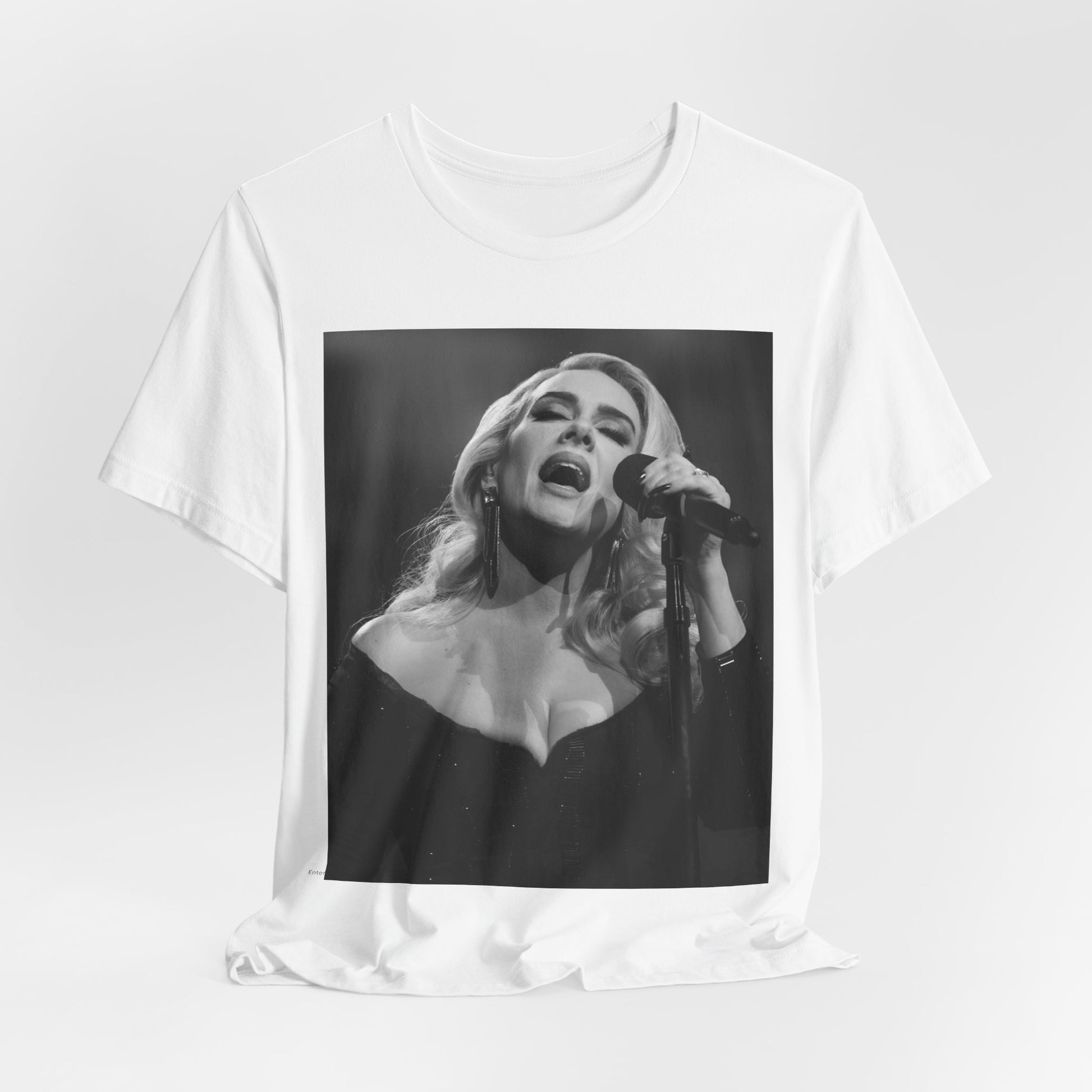 A black graphic t-shirt featuring a dynamic image of Adele performing on stage, with lighting effects, likely from her 'One Night Only' concert special.