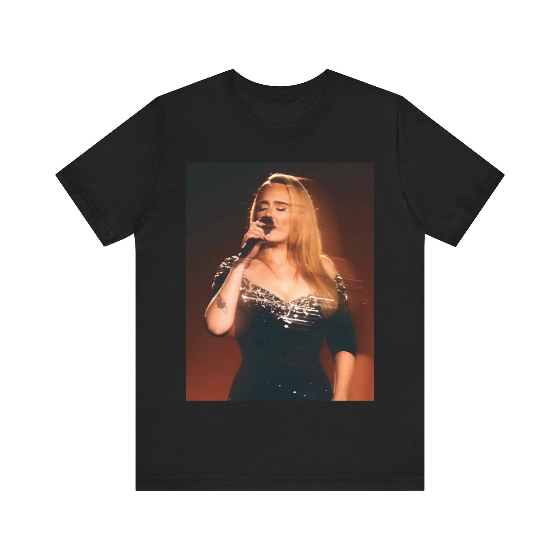 A black graphic t-shirt featuring a stylized image or photo of Adele related to her Las Vegas residency, possibly with elements of stage lighting or show branding.