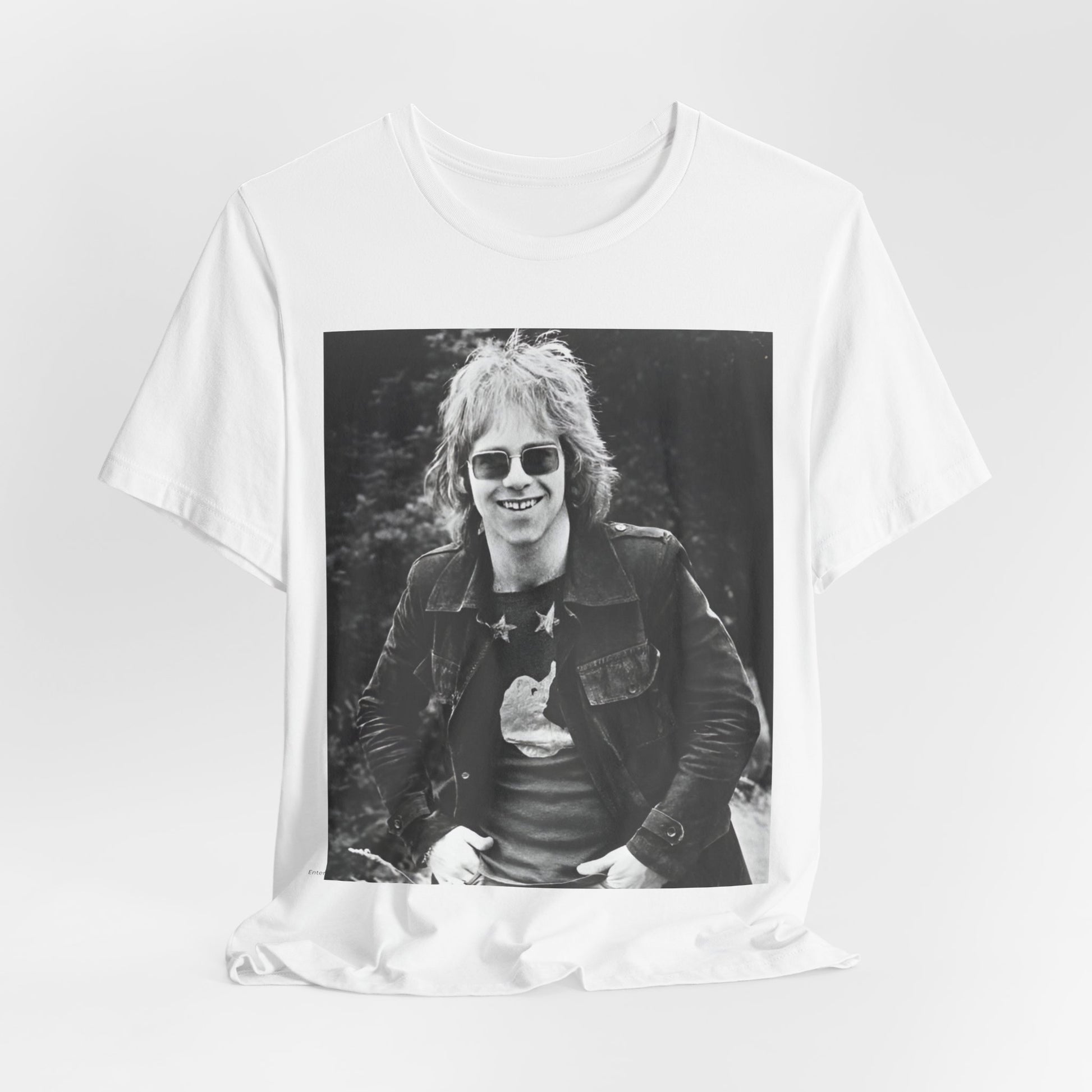 A black graphic t-shirt featuring a 70s black and white monochrome graphic or photo of Elton John.