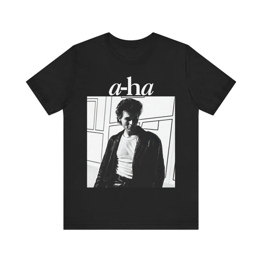 A black graphic t-shirt featuring a stylized pop art graphic inspired by A-HA's "Take On Me" music video from 1985.