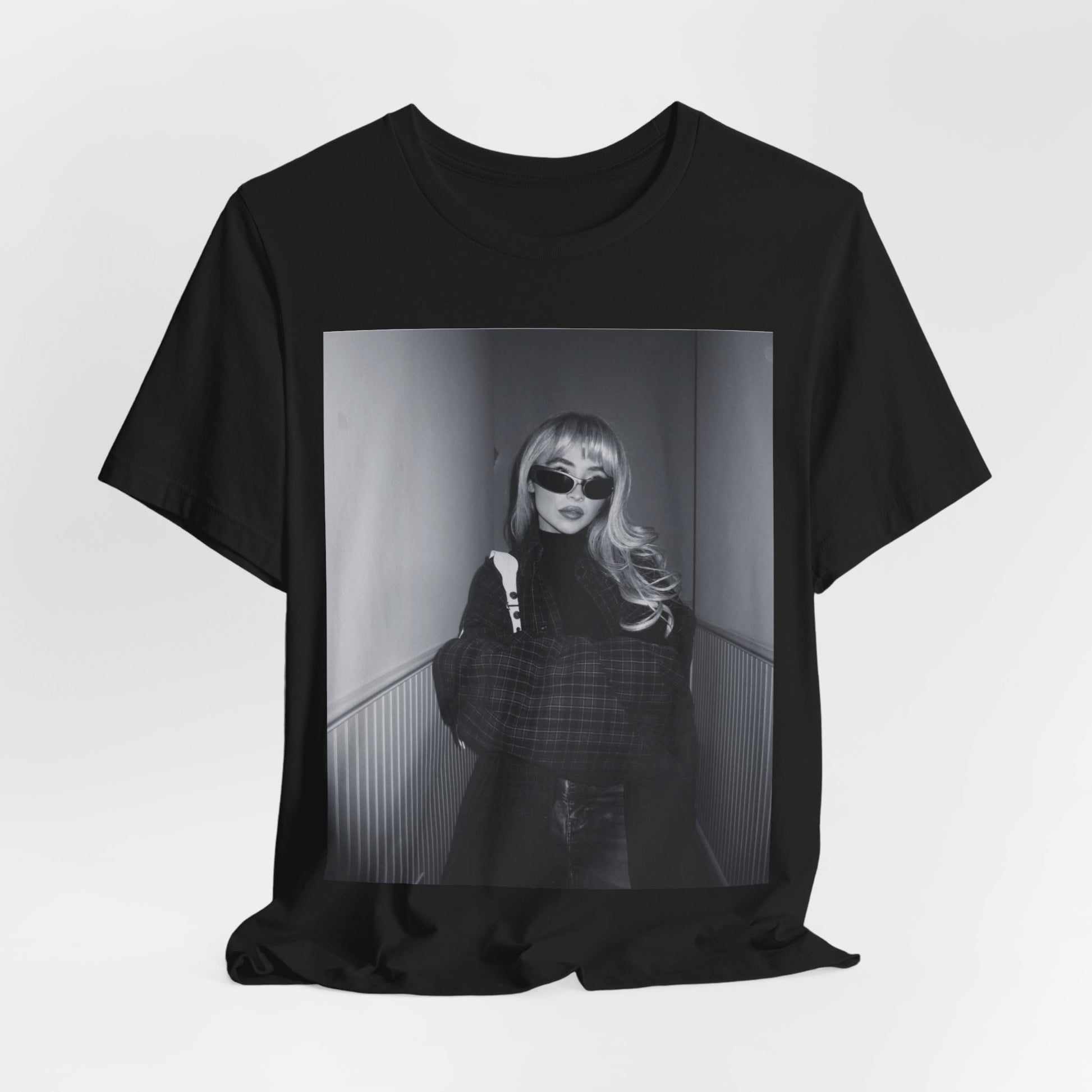 A black graphic t-shirt featuring a black and white glam pop diva graphic of Sabrina Carpenter.