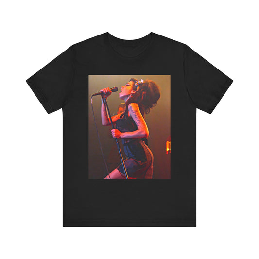 A black graphic t-shirt featuring a dynamic photo of Amy Winehouse performing live, with elements suggesting her 'Back to Black' era.