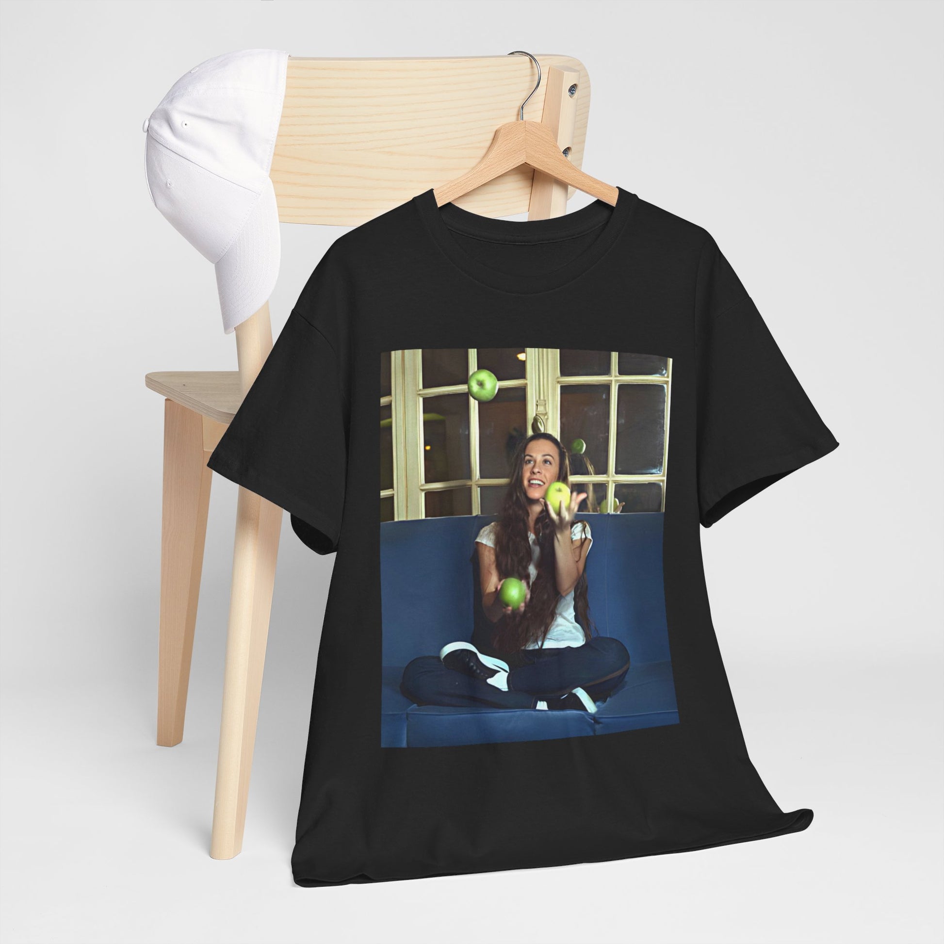 A black graphic t-shirt featuring a candid photo of Alanis Morissette sitting on a couch, looking relaxed or thoughtful.