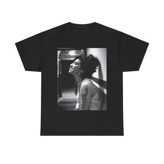 A black graphic t-shirt featuring a candid backstage photo of Amy Winehouse from her 'Back to Black' era, showing her in a relaxed setting.