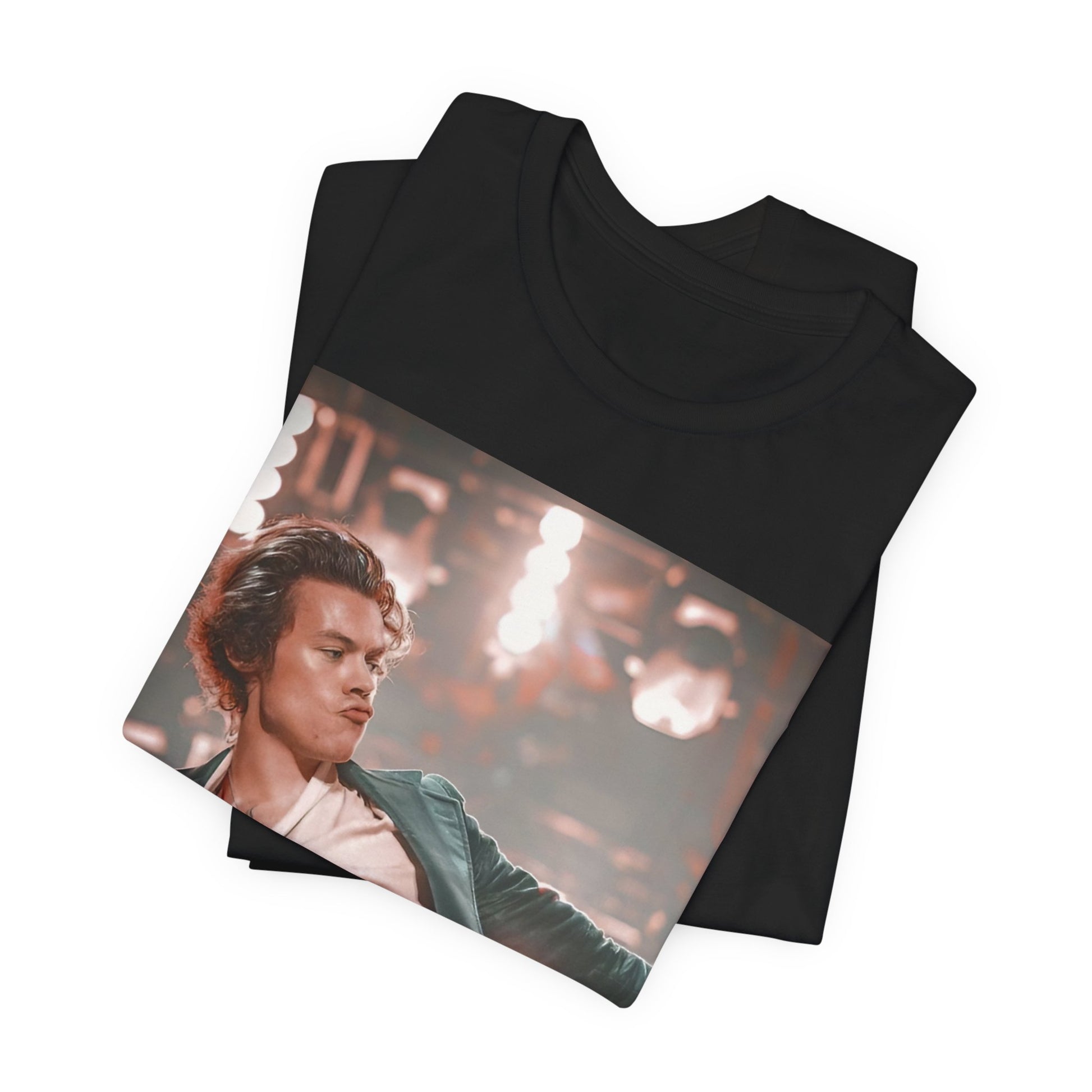 A black graphic t-shirt featuring a graphic or photo of Harry Styles performing live on concert tour.
