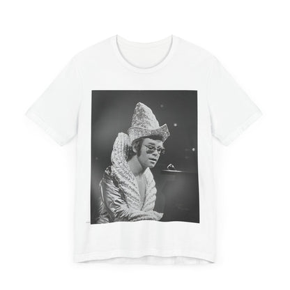 A black graphic t-shirt featuring a 70s pop aesthetic graphic of Elton John.