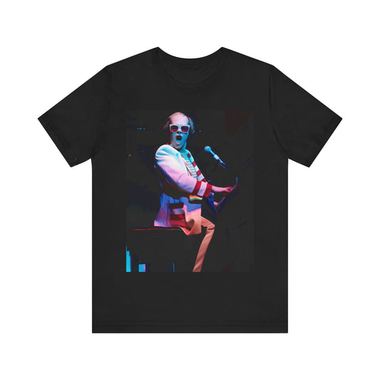 A black graphic t-shirt featuring a photo of Elton John performing live on stage at his piano.