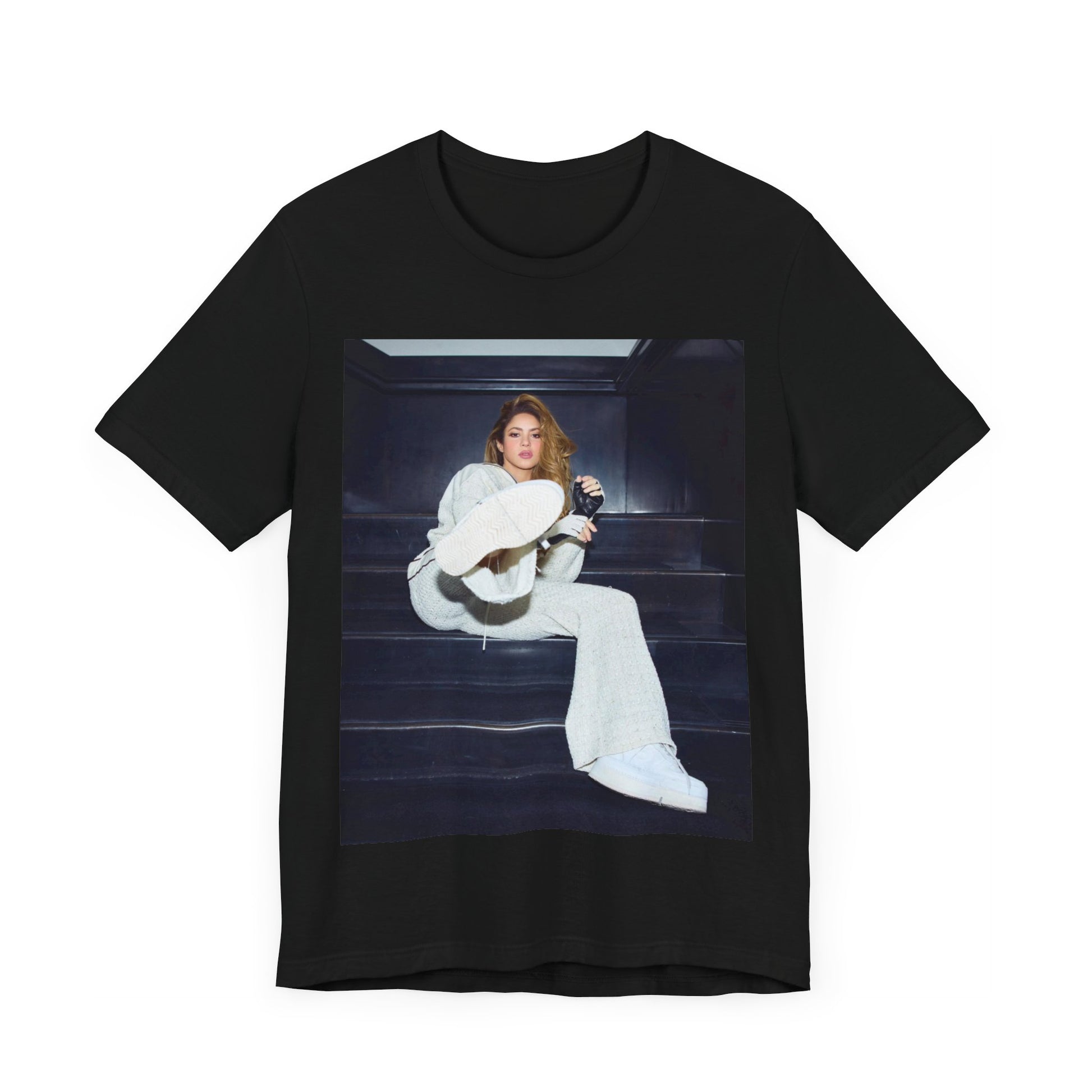 A black graphic t-shirt featuring a vintage Latin pop icon graphic of Shakira.
