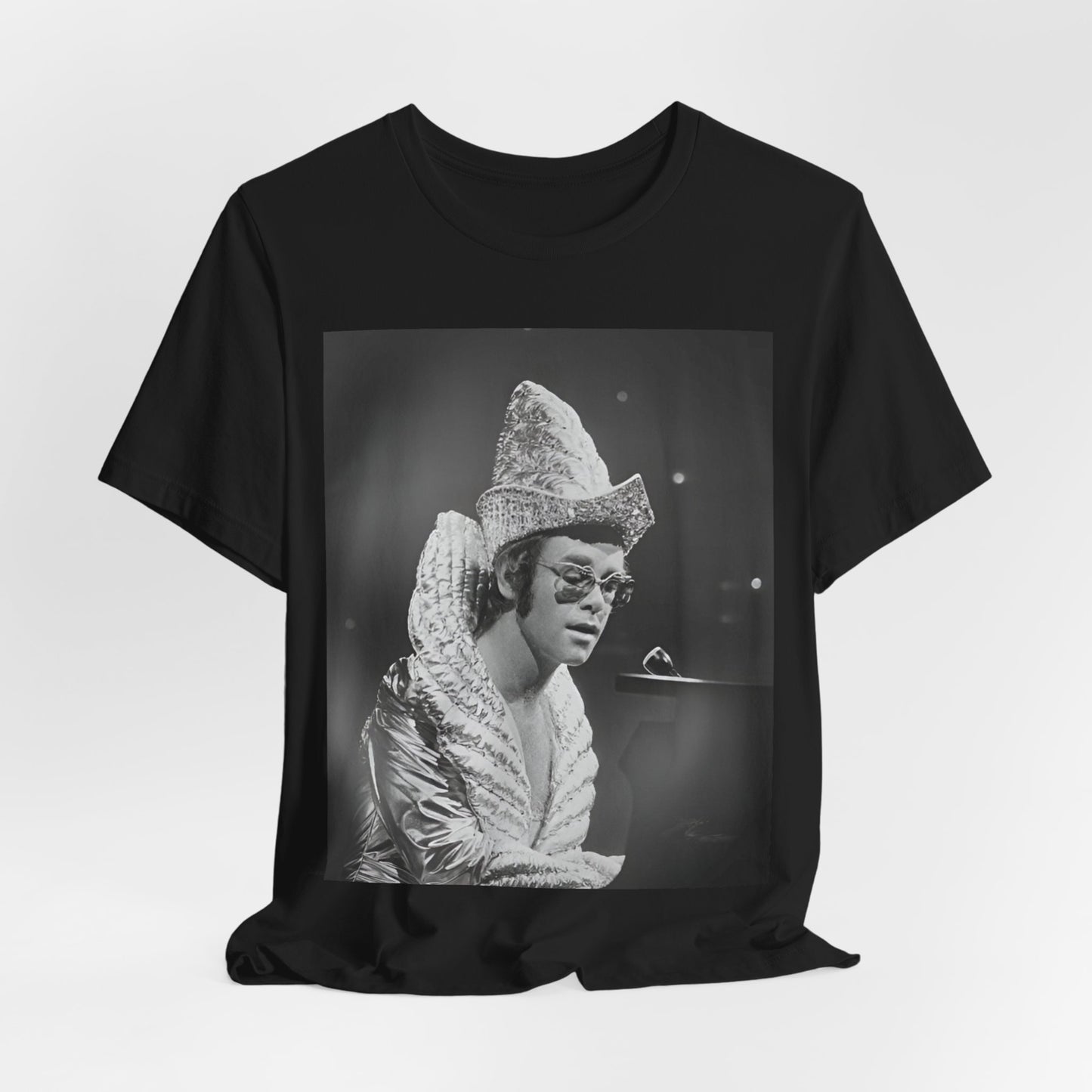 A black graphic t-shirt featuring a 70s pop aesthetic graphic of Elton John.