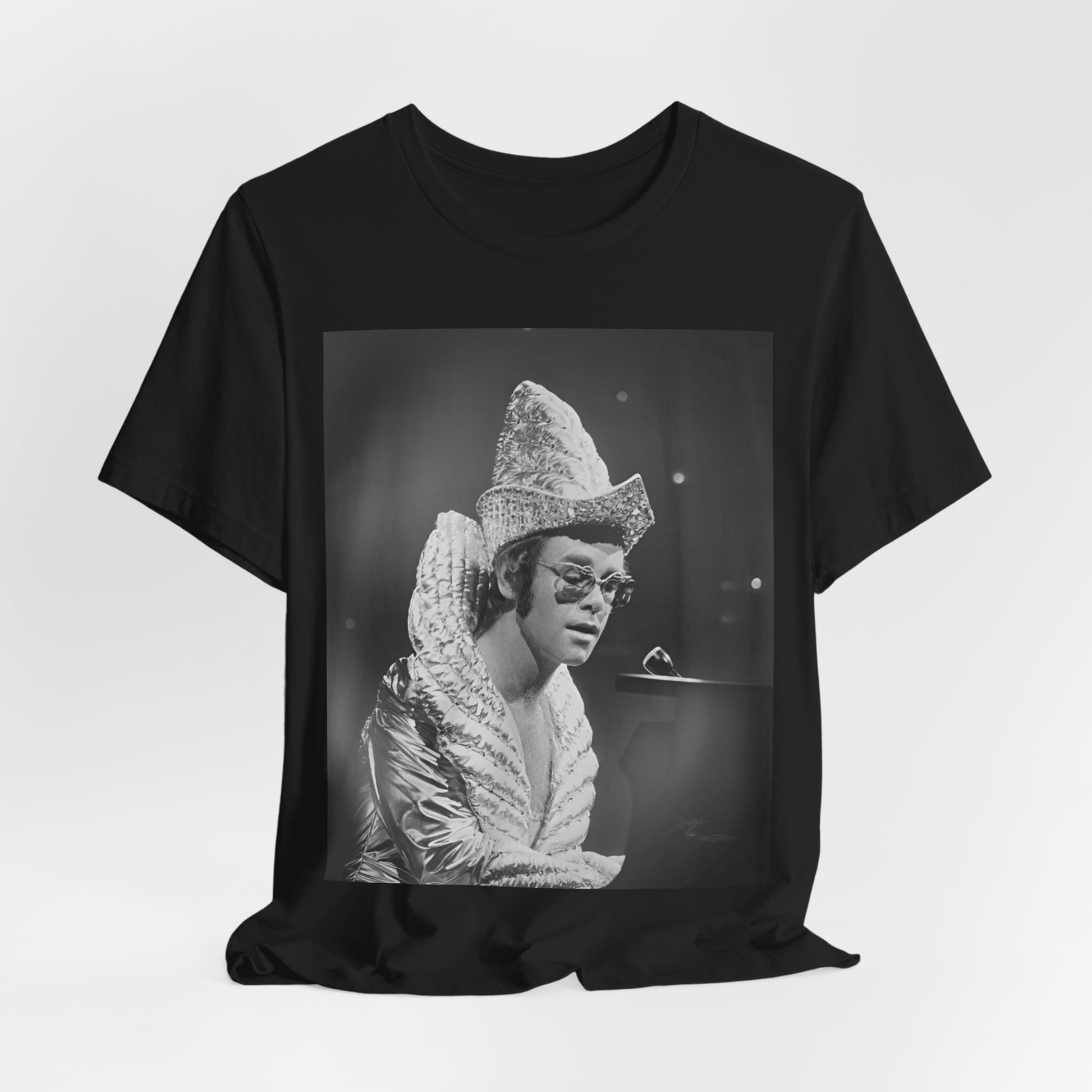 A black graphic t-shirt featuring a 70s pop aesthetic graphic of Elton John.
