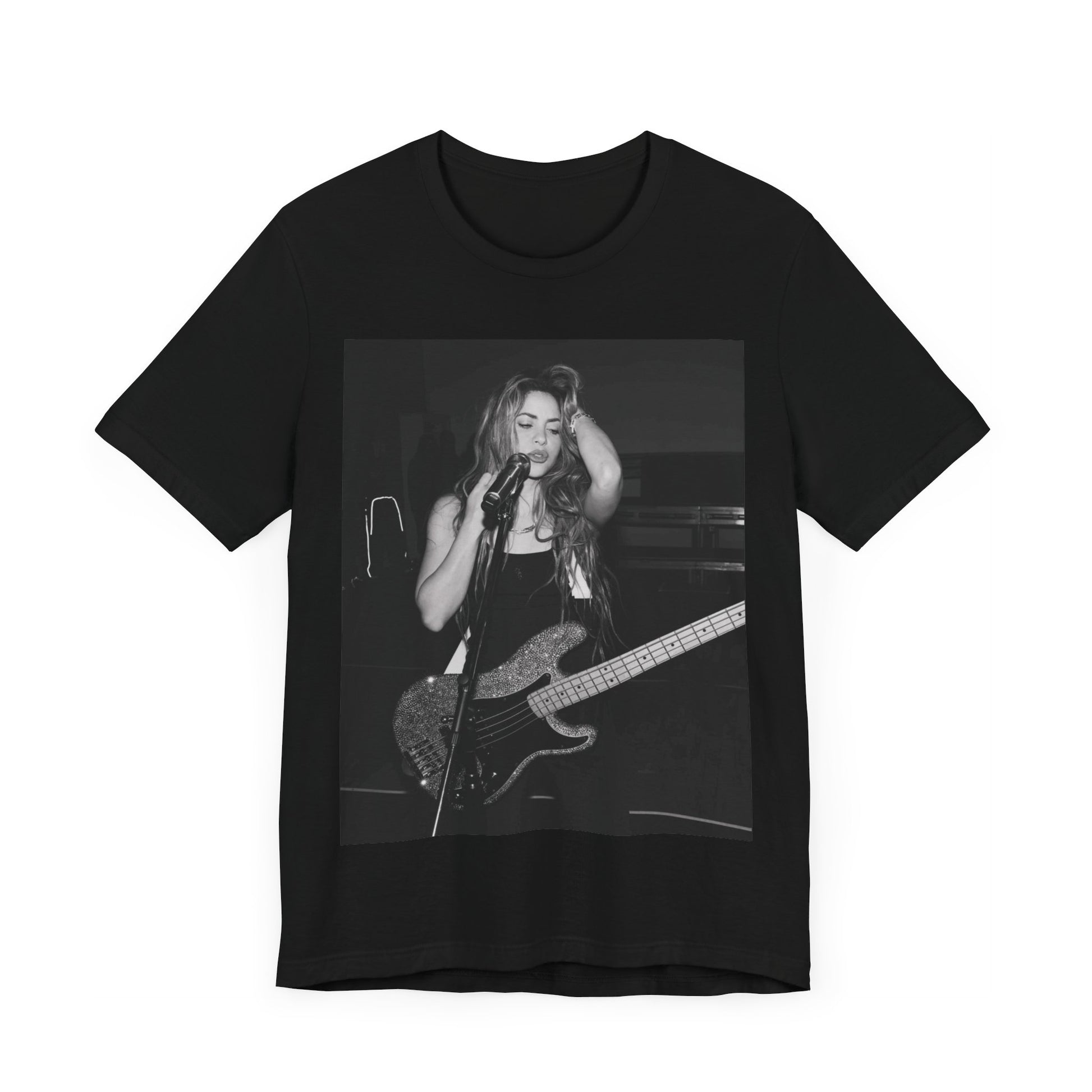 A black graphic t-shirt featuring a black and white graphic or photo of Shakira playing guitar live.
