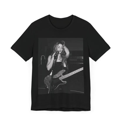 A black graphic t-shirt featuring a black and white graphic or photo of Shakira playing guitar live.
