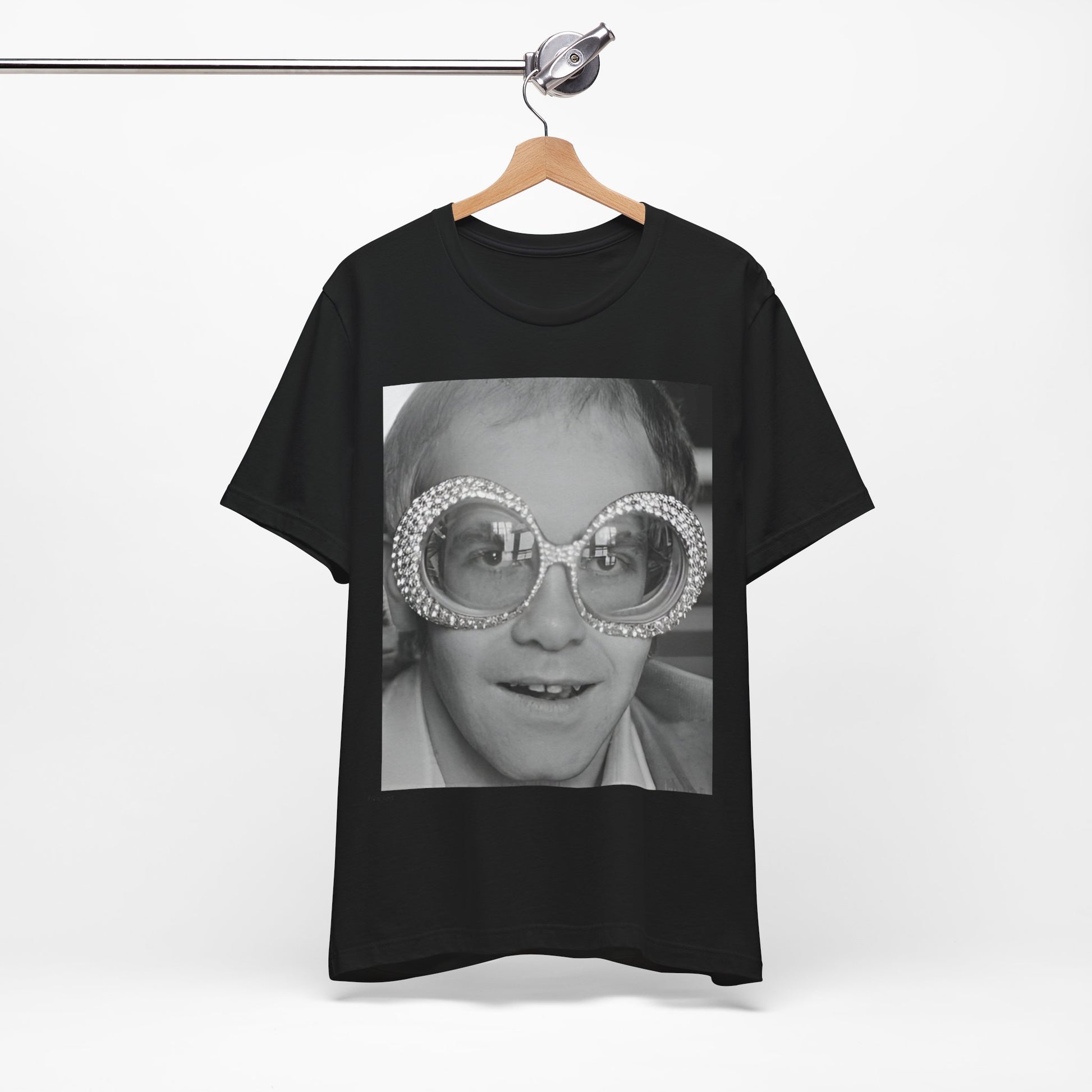 A black graphic t-shirt featuring a graphic of Elton John emphasizing his iconic glasses and fashion.