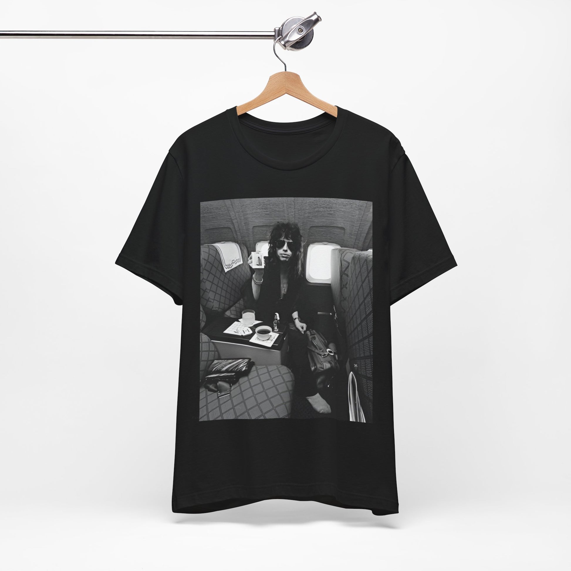 A black graphic t-shirt featuring a vintage 70s-style illustration of an airplane with Aerosmith branding, representing their tour plane from that era.