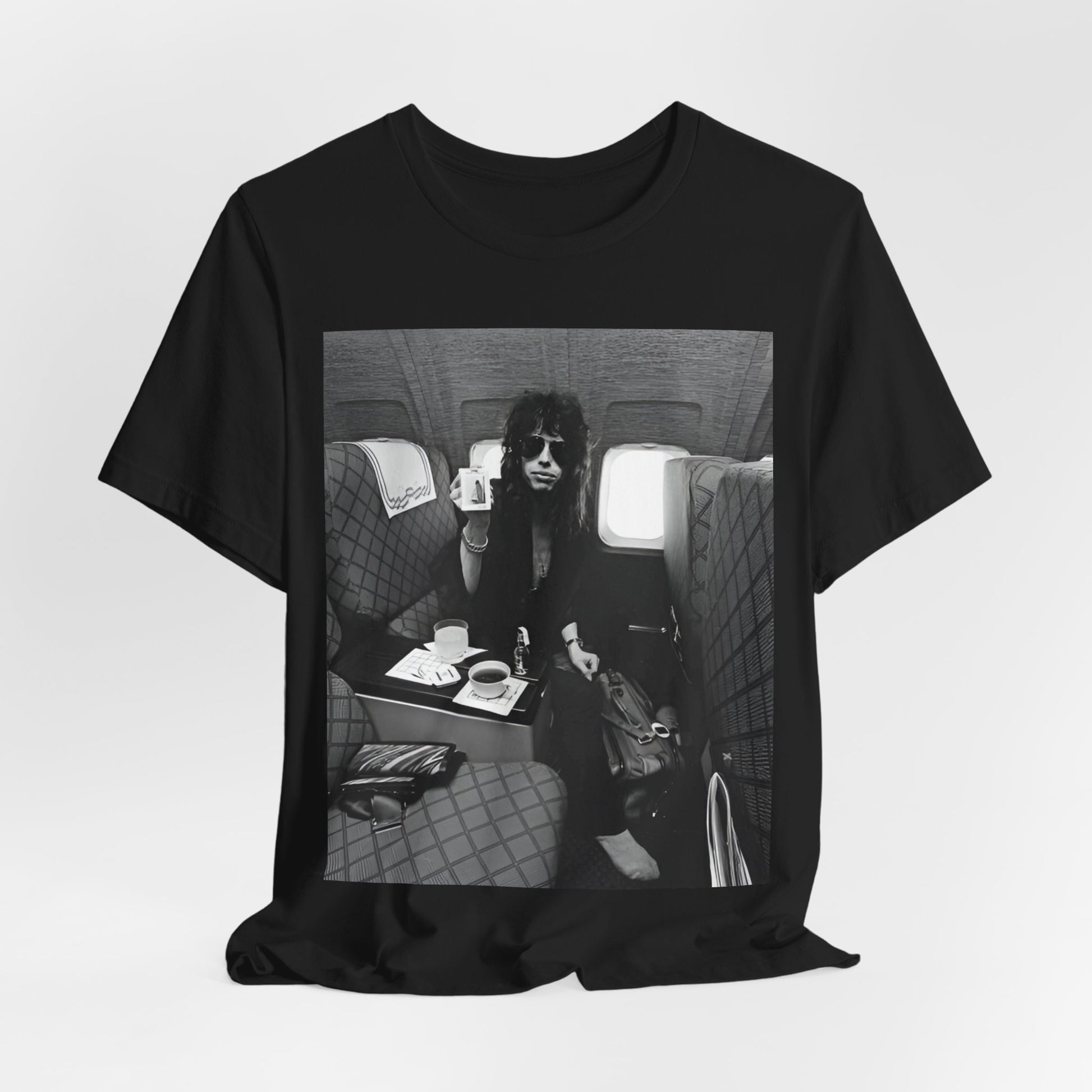 A black graphic t-shirt featuring a vintage 70s-style illustration of an airplane with Aerosmith branding, representing their tour plane from that era.