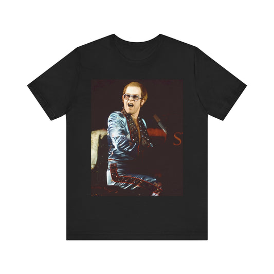 A black graphic t-shirt featuring a retro graphic related to Elton John's 'Rocket Man' song or era.