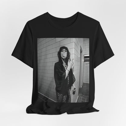 A black graphic t-shirt featuring a retro 70s photo of Aerosmith band members in a backstage setting, showing a candid moment.