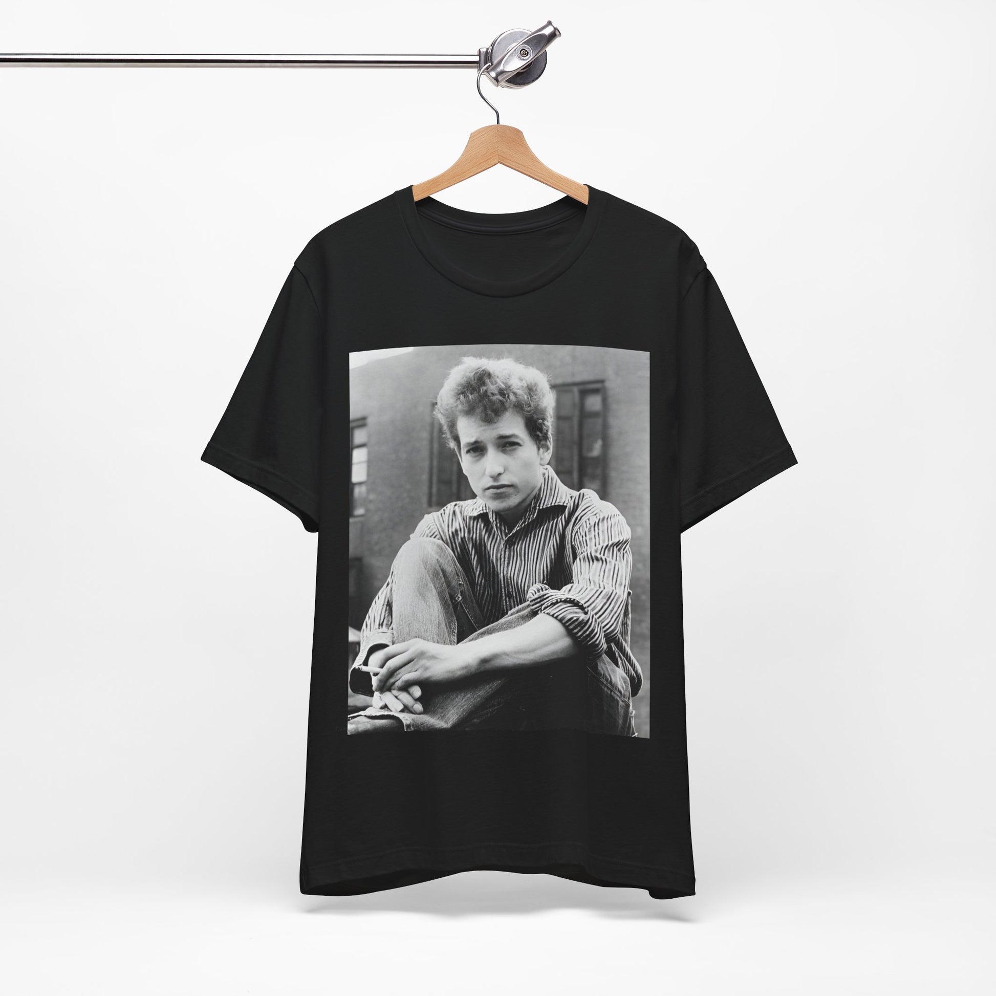 A black graphic t-shirt featuring a graphic of Bob Dylan from his 60s origins in folk music.