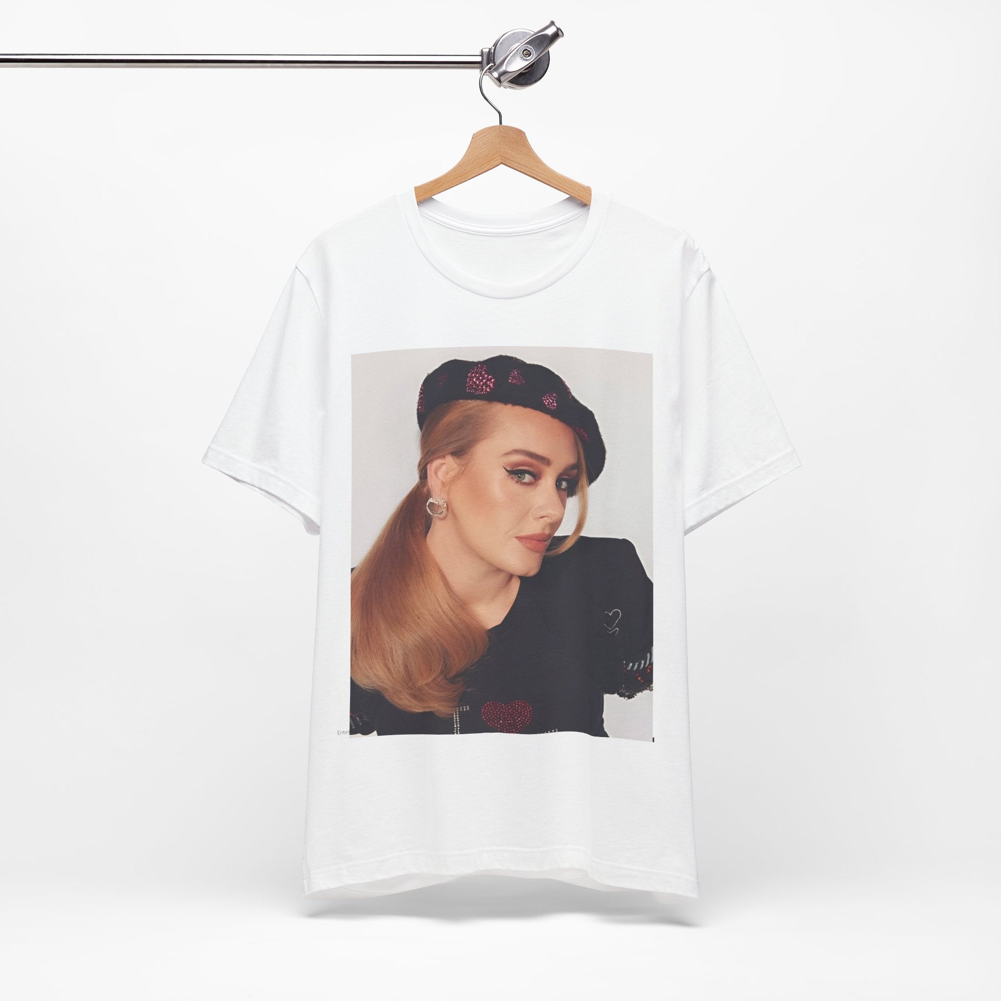 A black graphic t-shirt featuring a black and white photo of Adele wearing a heart-shaped beret, with a gentle or smiling expression.