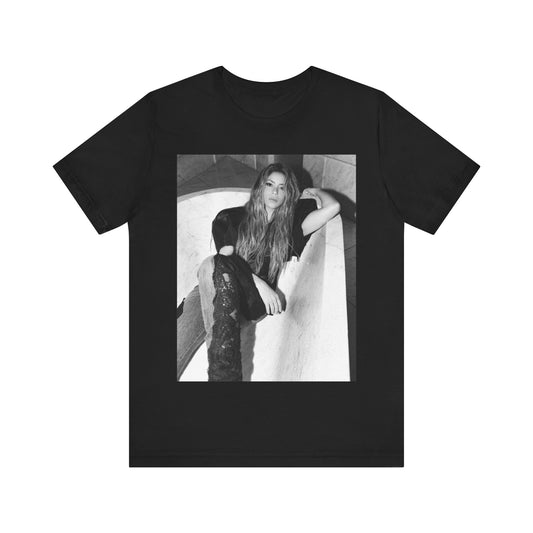 A black graphic t-shirt featuring a retro graphic related to Shakira's 'Hips Don't Lie' song or era.