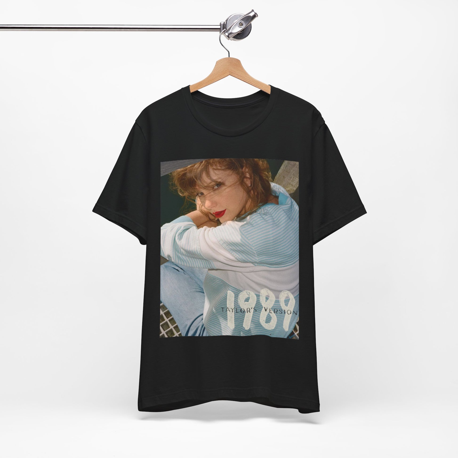 A black graphic t-shirt featuring a 1989 aesthetic graphic of Taylor Swift.