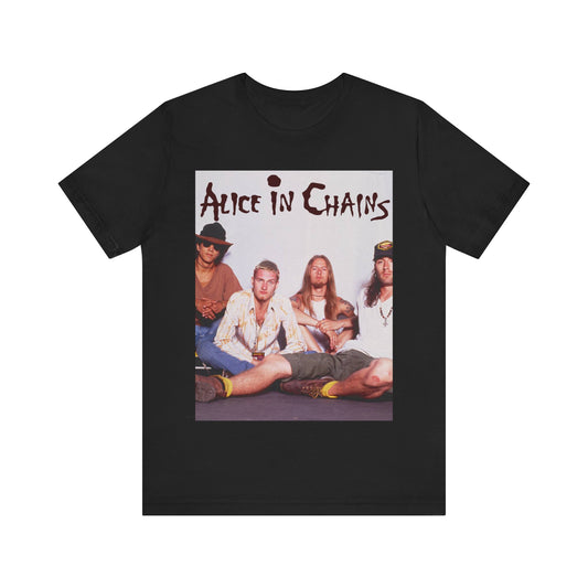 A black graphic t-shirt featuring a classic rock graphic of Alice In Chains from the 1990s, possibly with band members or stylized logo.