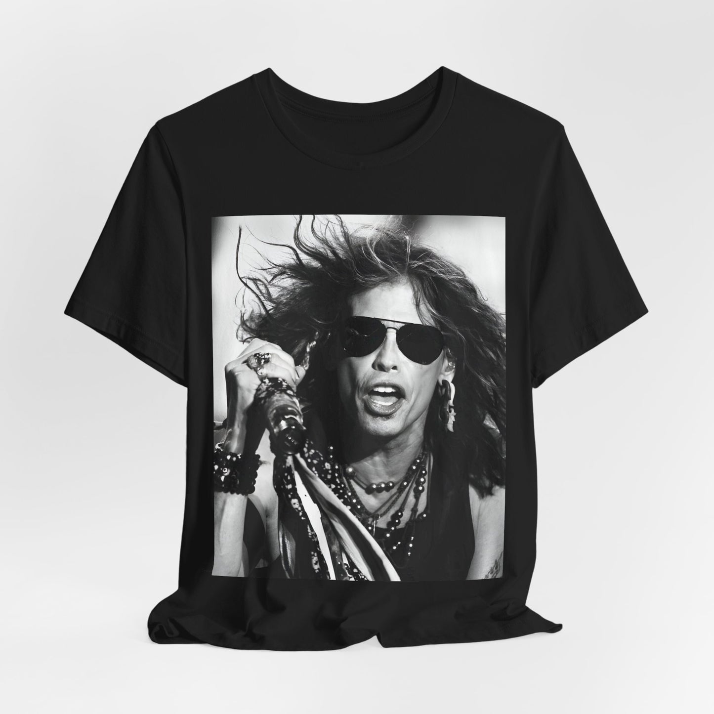 A black graphic t-shirt featuring a black and white photo of Aerosmith's Steven Tyler with his signature scarf and microphone, captured during a dynamic performance.